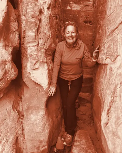 Hiker standing between narrow slot canyon walls